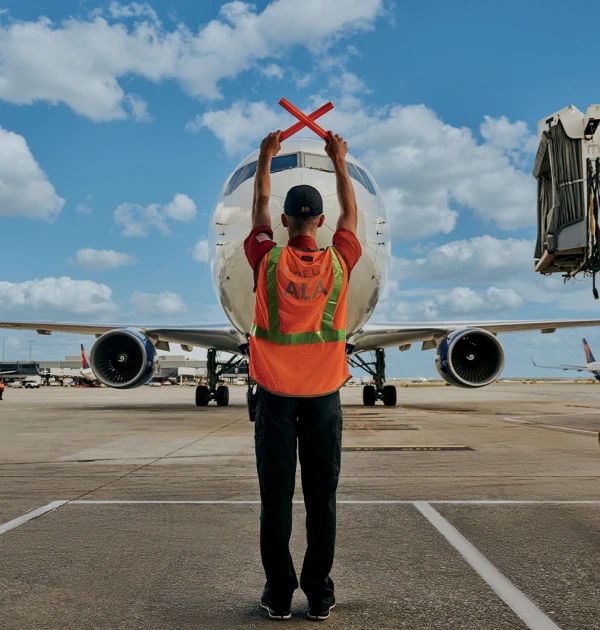 Ground crew guiding airplane on runway