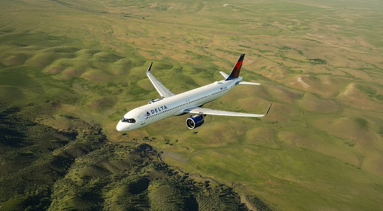 Airplane flying over green landscape