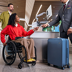 Delta customer checking her luggage with a ticket agent.