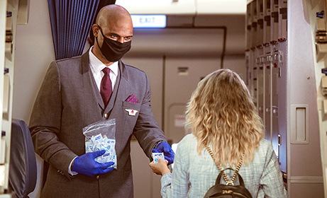 un auxiliar de vuelo ofrece desinfectante para manos