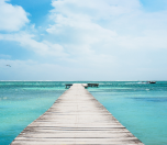 Wooden dock extending over turquoise water