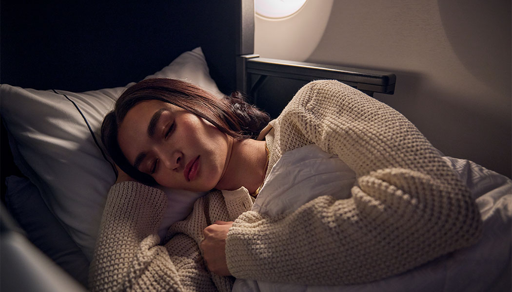 Woman sleeping in a Delta One flat-bed seat