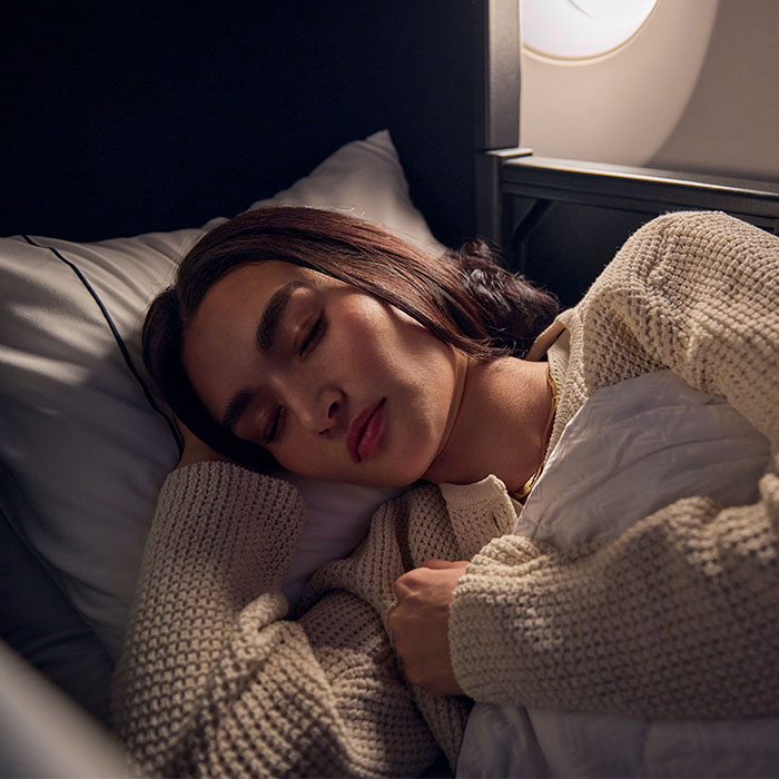 Woman sleeping in a Delta One flat-bed seat
