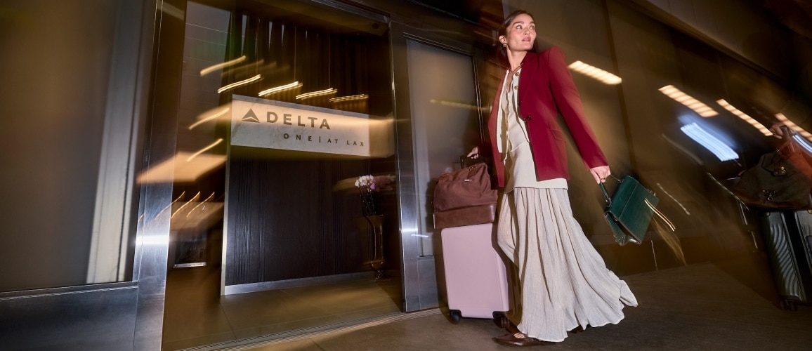 Mulher elegante caminha pelo LAX perto de um lounge Delta One