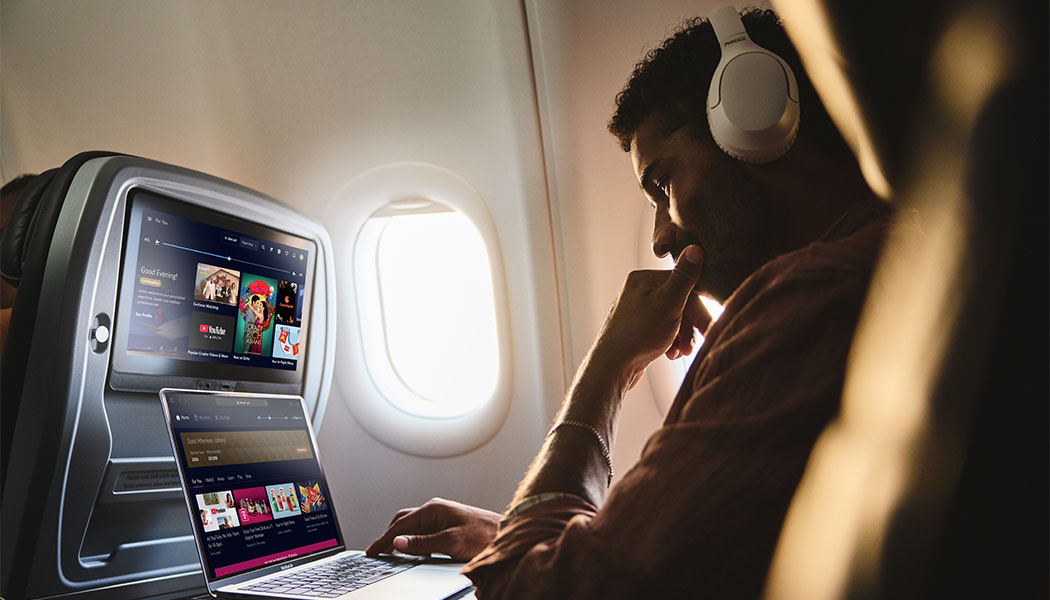 Man on airplane using laptop