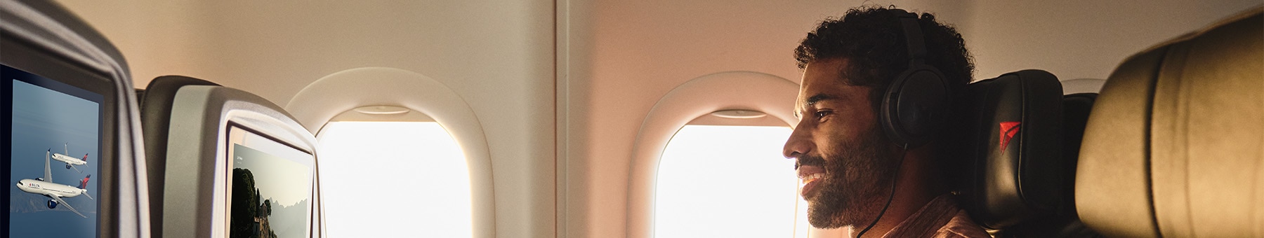 A male passenger listening to music with headphones.