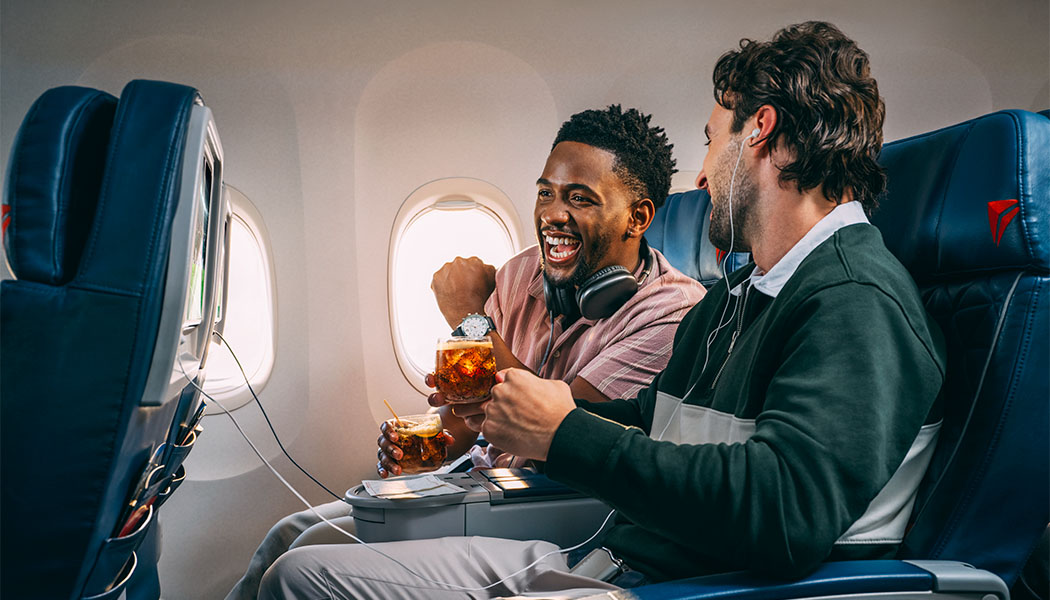 Two men cheering while watching live TV
