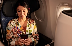 Women sitting on airplane looking at mobile phone