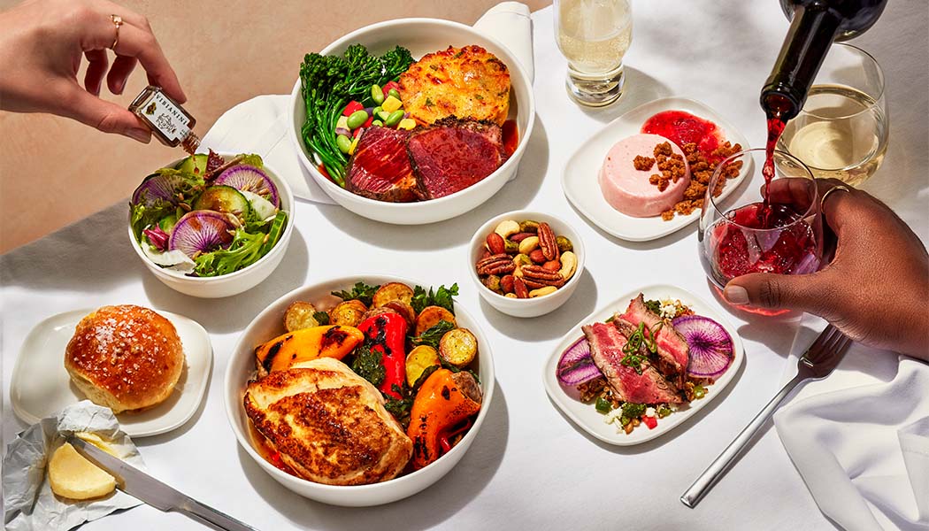 Assortment of onboard food and beverages, including main courses, salads, side dishes and wine