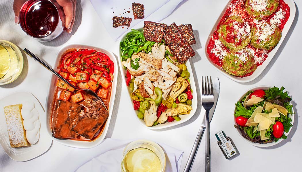 Assortment of onboard food and beverages, including main courses, salads, side dishes and wine