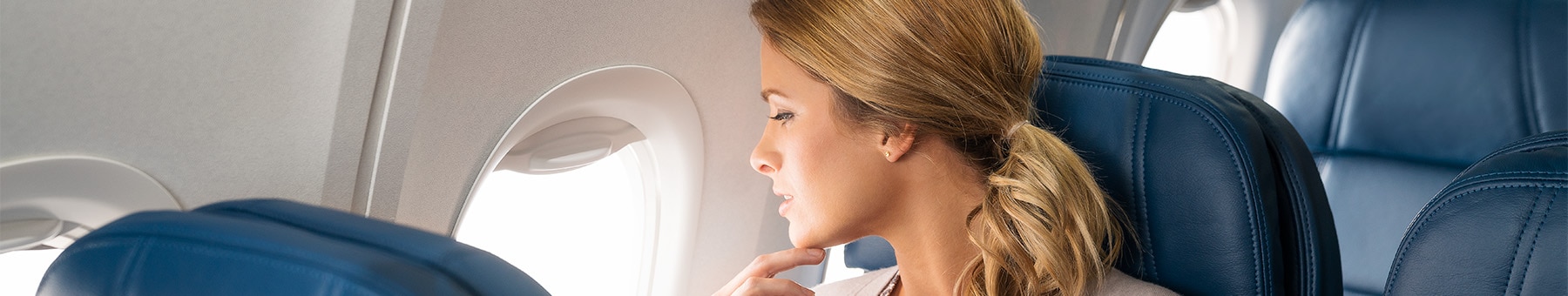 Woman looking ou the window from Delta Main seat.