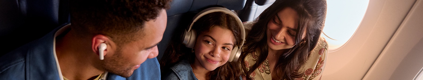 Little girl with headphones on enjoying inflight entertainment