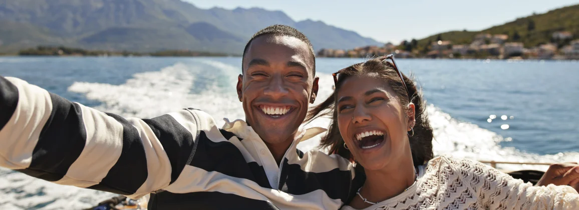 Two people taking selfie on boat, highlighting Delta SkyMiles travel rewards.
