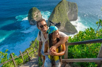 Couple overlooking tropical cliffs and ocean, highlighting Delta SkyMiles travel rewards.