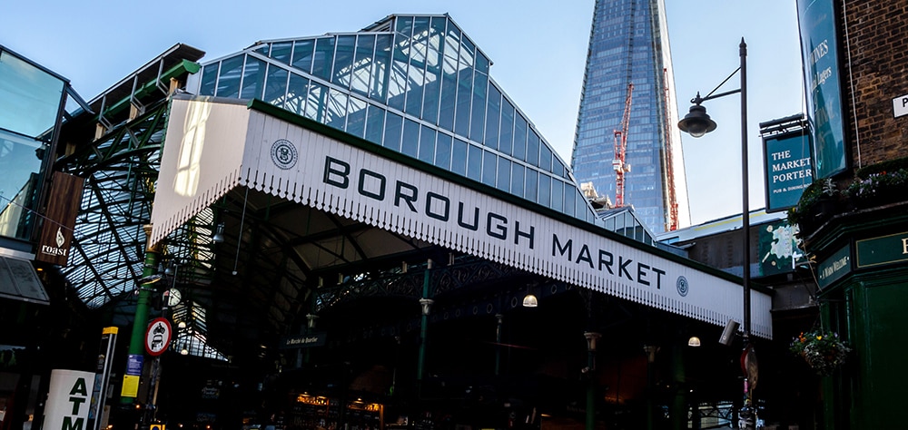Borough Market entrance in London with glass roof and iconic market sign. 