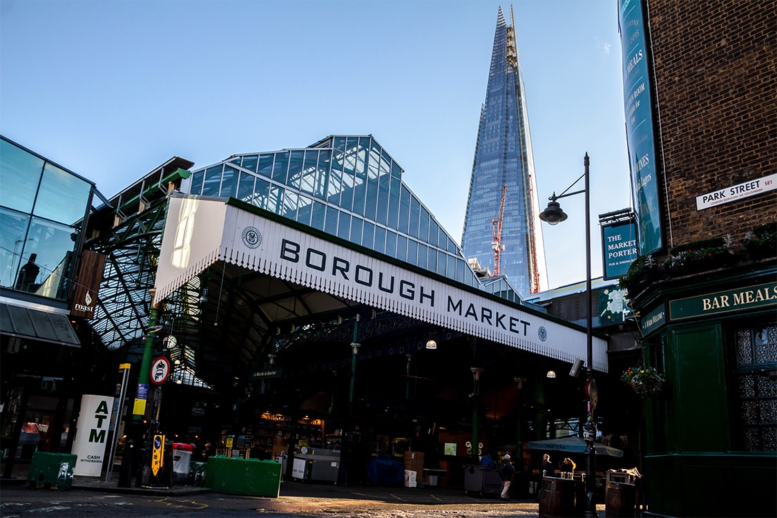 Borough Market entrance in London with glass roof and iconic market sign. 