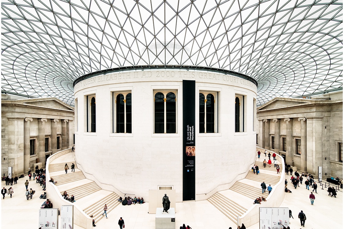 Interior of the British Museum Great Court featuring the historic Reading Room and modern glass ceiling. 
