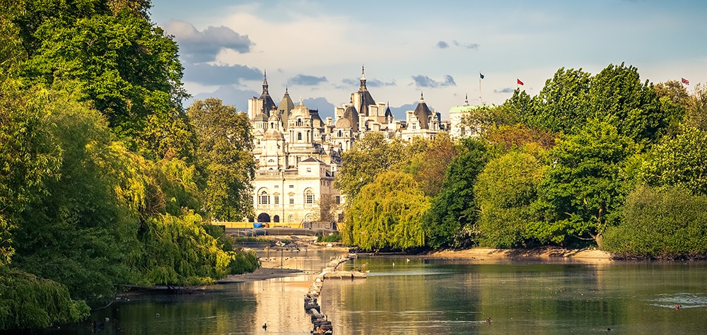 View across St James's Park toward Whitehall and Horse Guards buildings surrouned by greenery. 