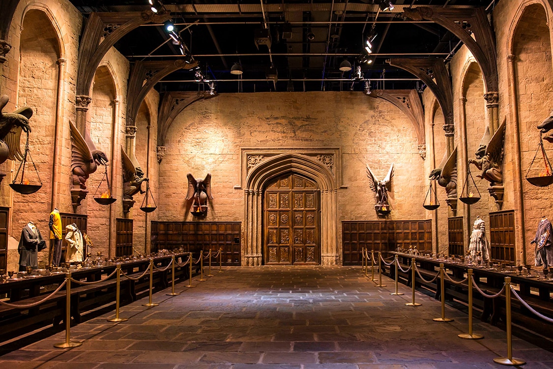 Hogwarts Great Hall set at Warner Bros Studio Tour London with medieval stone architecture and house displays.