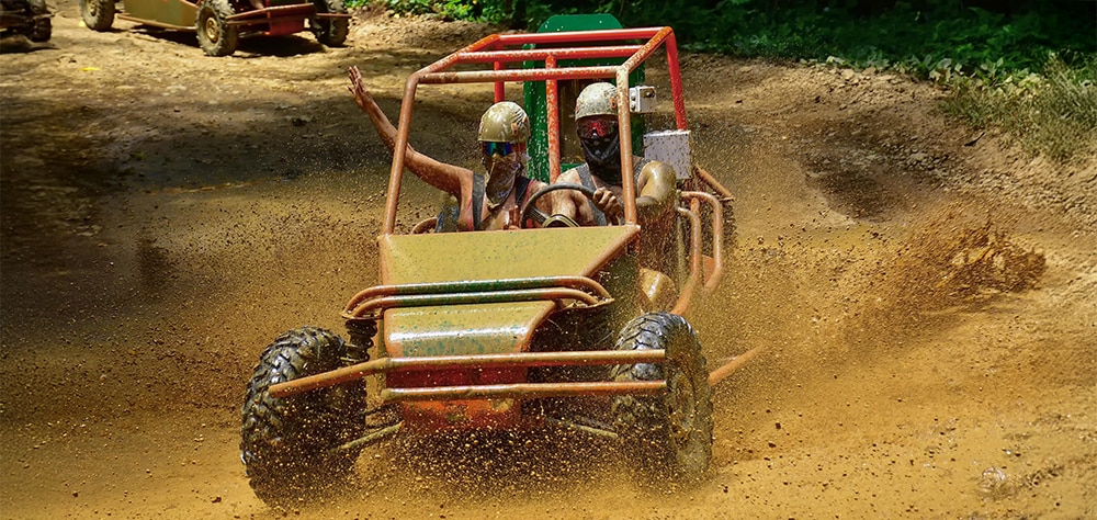 Couple in a 4x4 Jungle Buggie with goggles and helmets. 