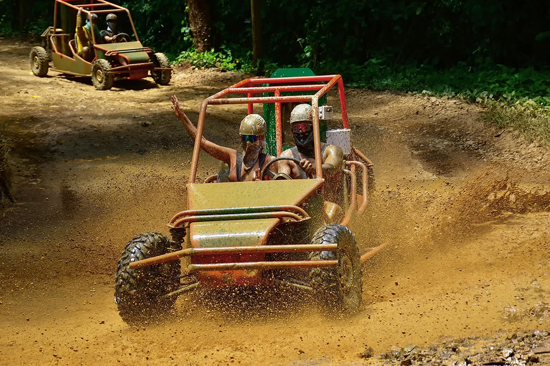Couple in a 4x4 Jungle Buggie with goggles and helmets. 