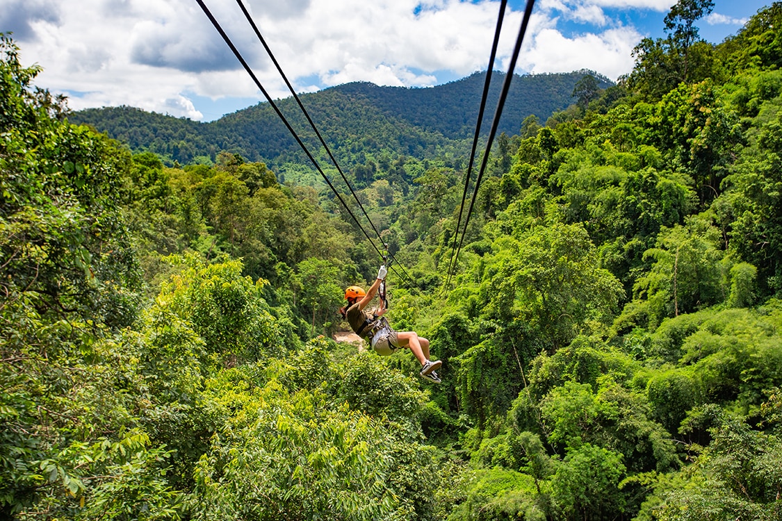 Traveler ziplining through lush green jungles in Punta Cana. 