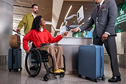 Customer in wheelchair using check bag service.