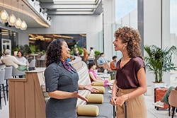 Woman chatting with employee at Delta Sky Club